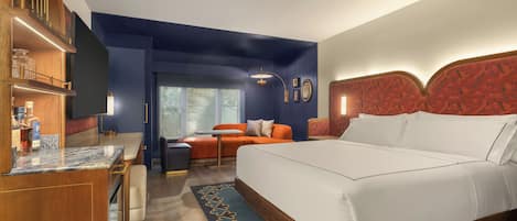 Une chambre d’hôtel avec un lit, un bureau, un canapé et une vue sur l’extérieur.