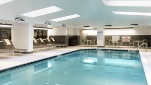 A modern indoor swimming pool with clear water, lounge chairs, and a pool emergency shut-off switch. - The Lowline Hotel, part of JdV by Hyatt Charleston (Charleston)