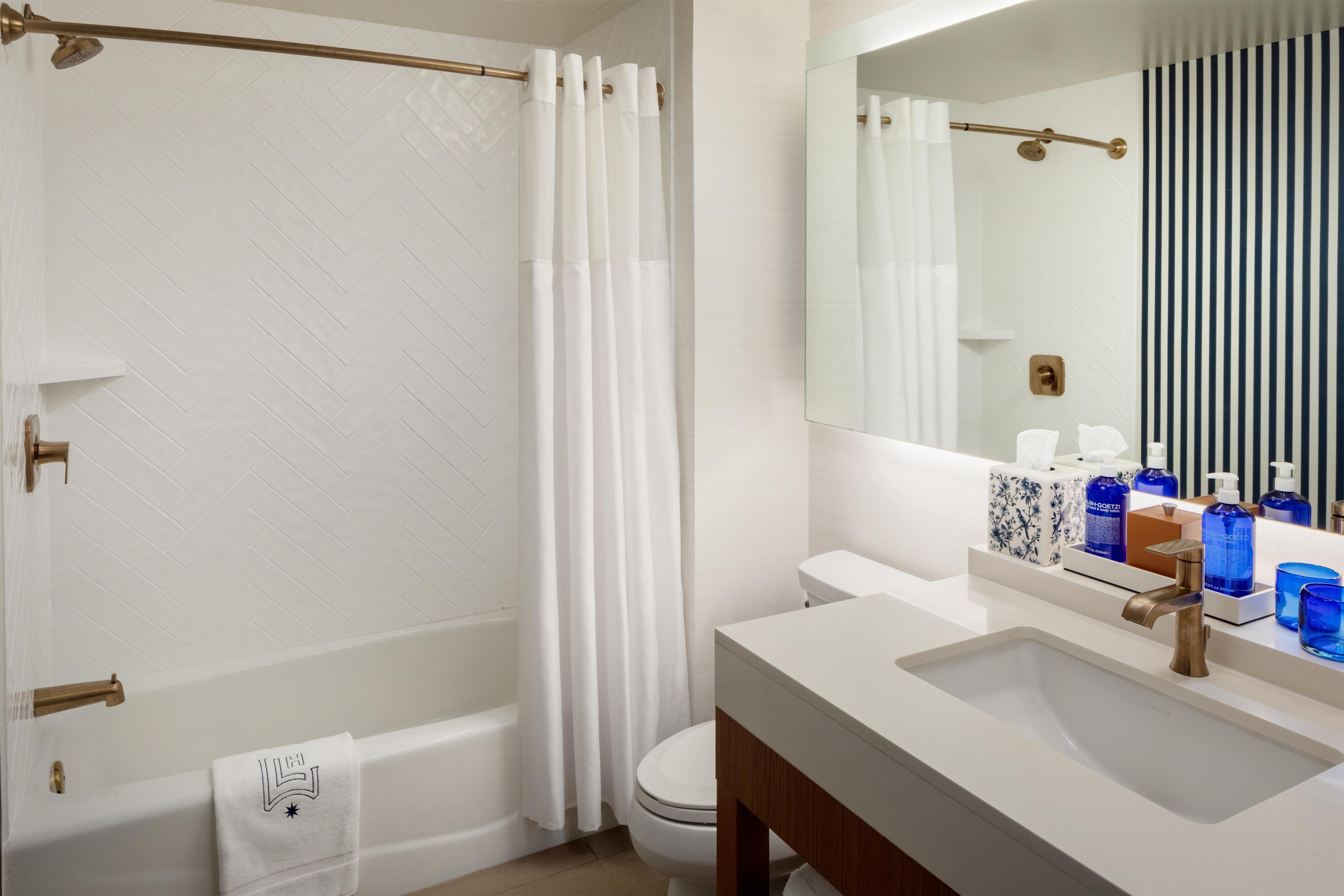 A bathroom with a bathtub, toilet, and sink.