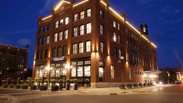 A brick building with multiple floors, large windows, and a sign for 'Pharmacy'. - The Charmant Hotel (La Crosse)