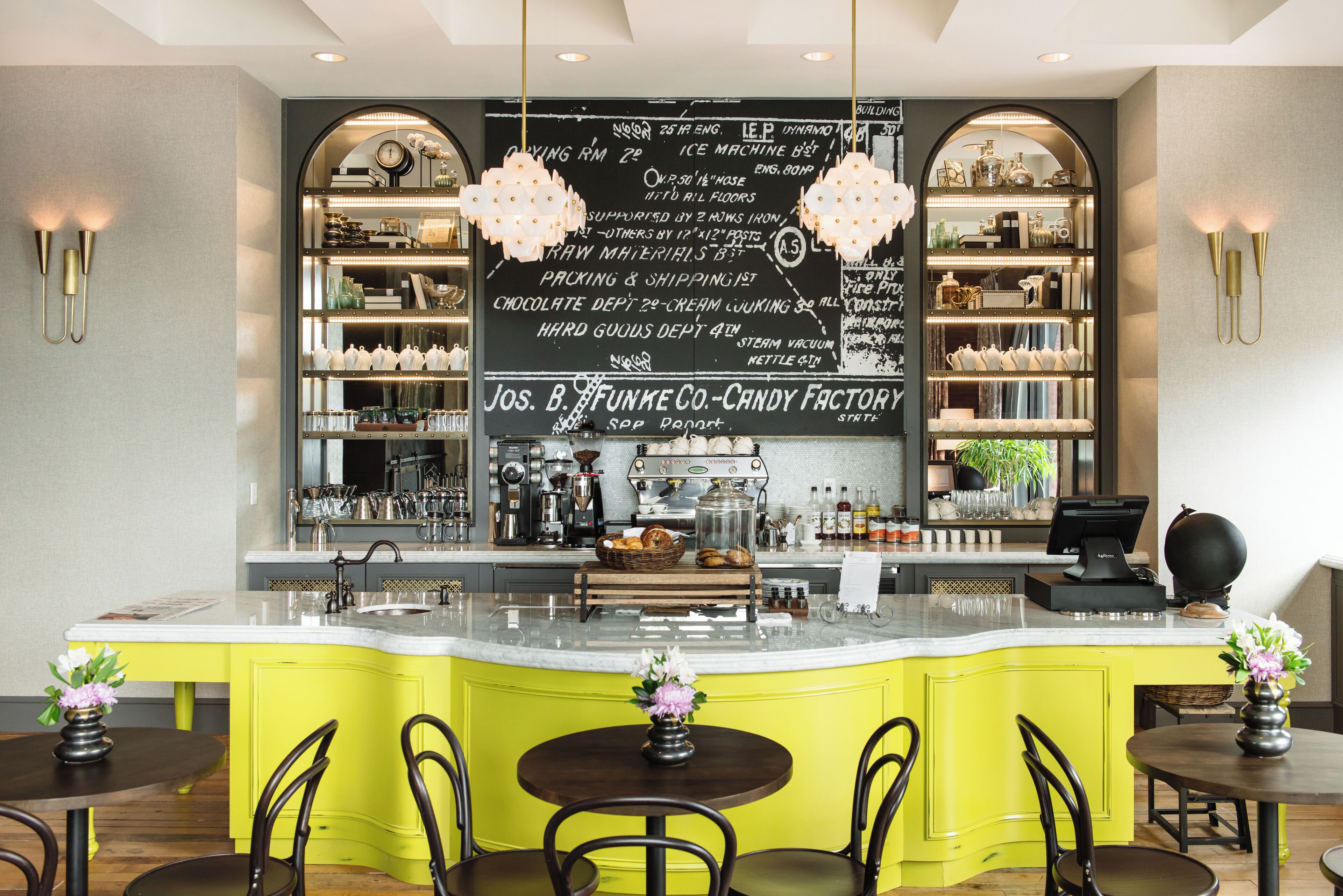 A bar area with a neon sign, a cash register, and a menu board.