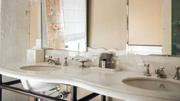 Casa de banho com duas pias, um espelho e um porta-toalhas.