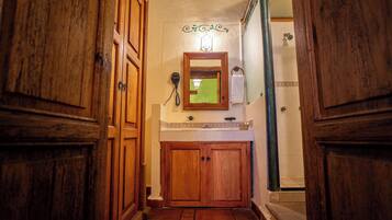 A narrow hallway with wooden doors, a small mirror, and a wall-mounted telephone.