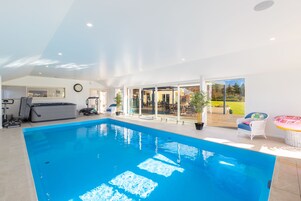 Una piscina cubierta, tumbonas