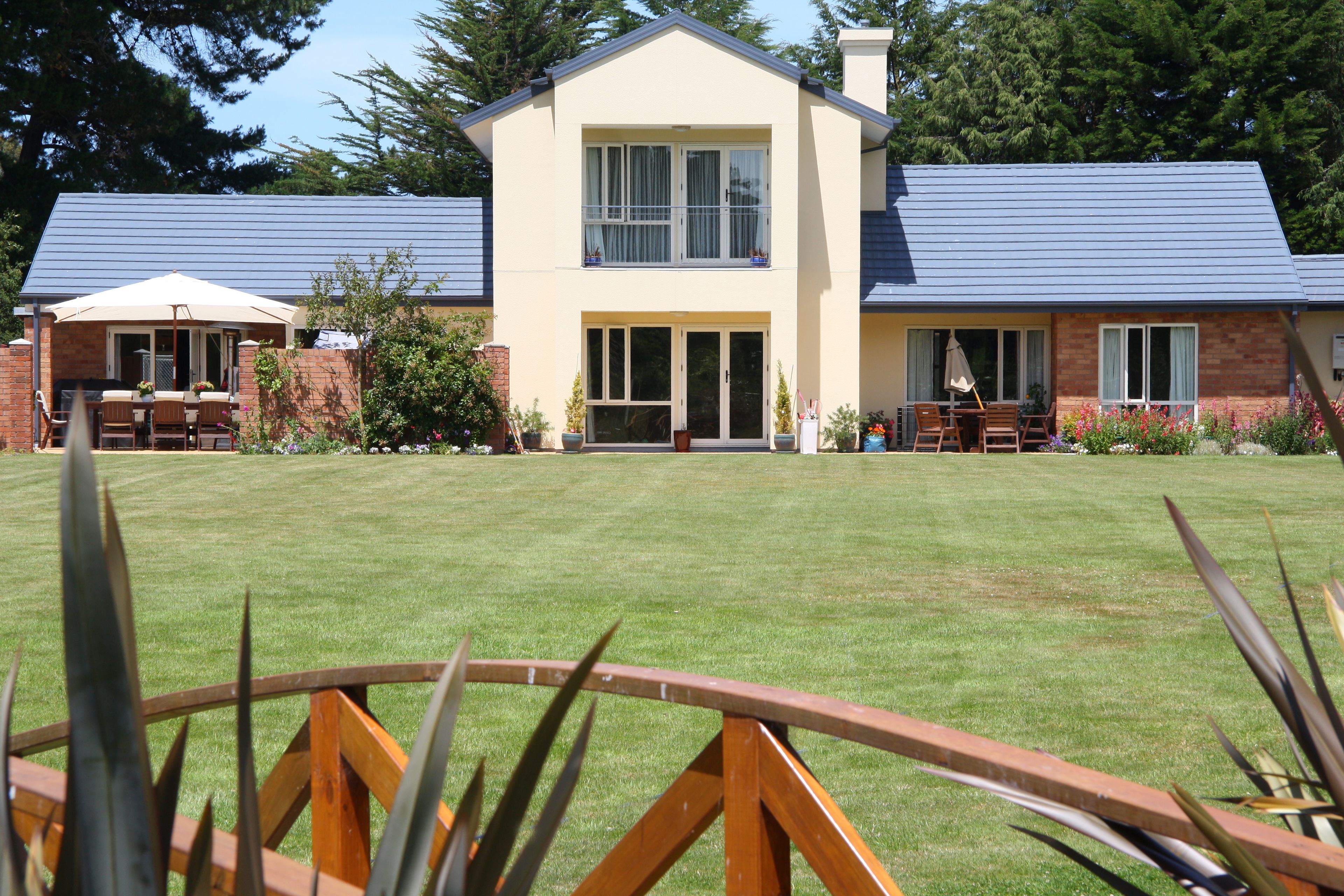 A two-story building with a flat roof, large windows, and a well-maintained lawn.