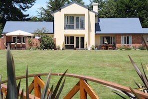 A two-story building with a flat roof, large windows, and a well-maintained lawn.
