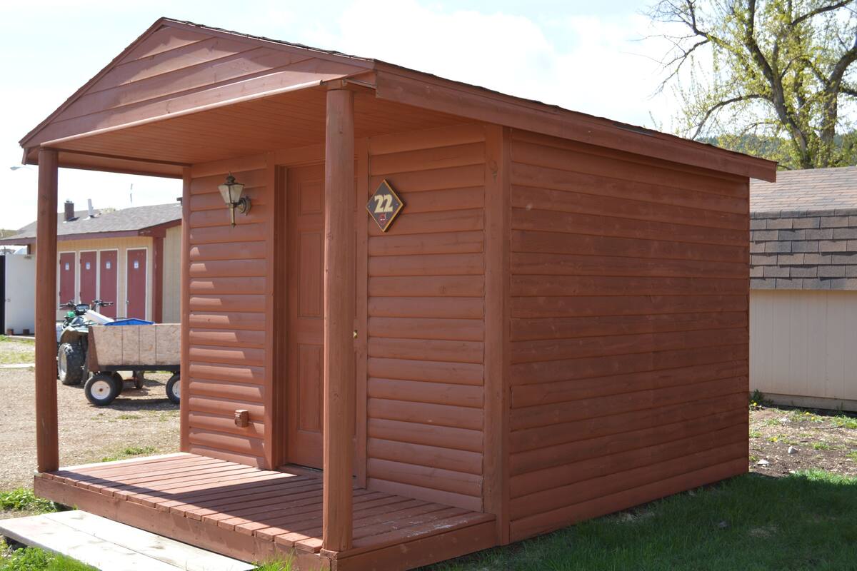 A wooden shed with a covered porch and a number "22" sign.