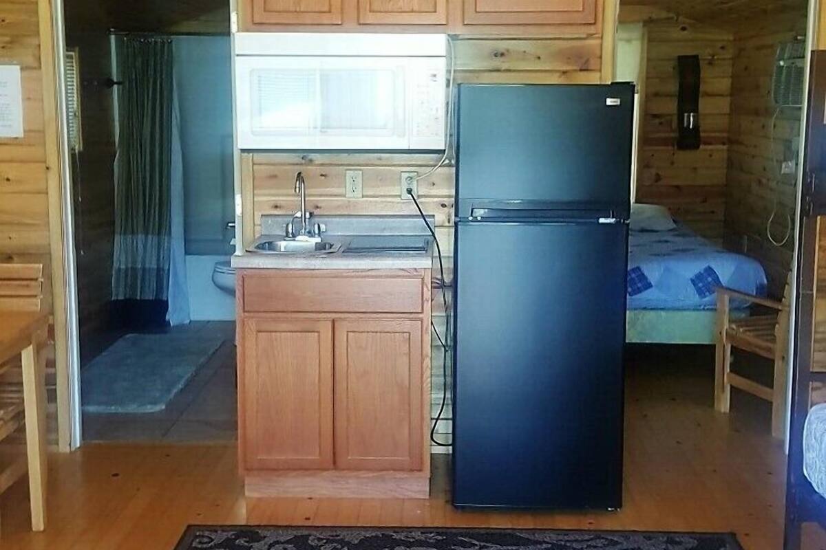 A compact cabin with wooden walls and a kitchenette.