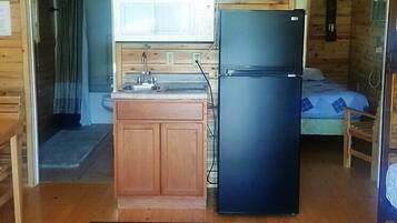 A compact cabin with wooden walls and a kitchenette.