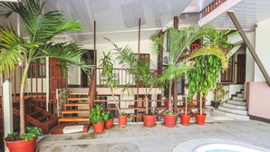 A pool area with potted plants and a staircase. - Hotel Flor Blanca (Quepos)