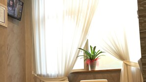 A living room with a sofa, a coffee table, and a potted plant. - Hotel Montecarlo (Milan)