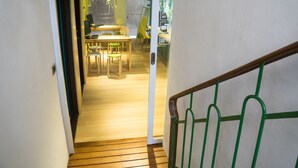 A wooden staircase leading to a dining area with a table and chairs. - 英倫旅店 - Baker Street Guesthouse (Tainan)
