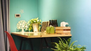 A room with teal walls, a wooden desk, a red chair, and two potted plants. - 英倫旅店 - Baker Street Guesthouse (Tainan)