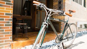 A bicycle parked outside a building with a brick facade and a wooden deck. - 日木民宿 (Tainan)