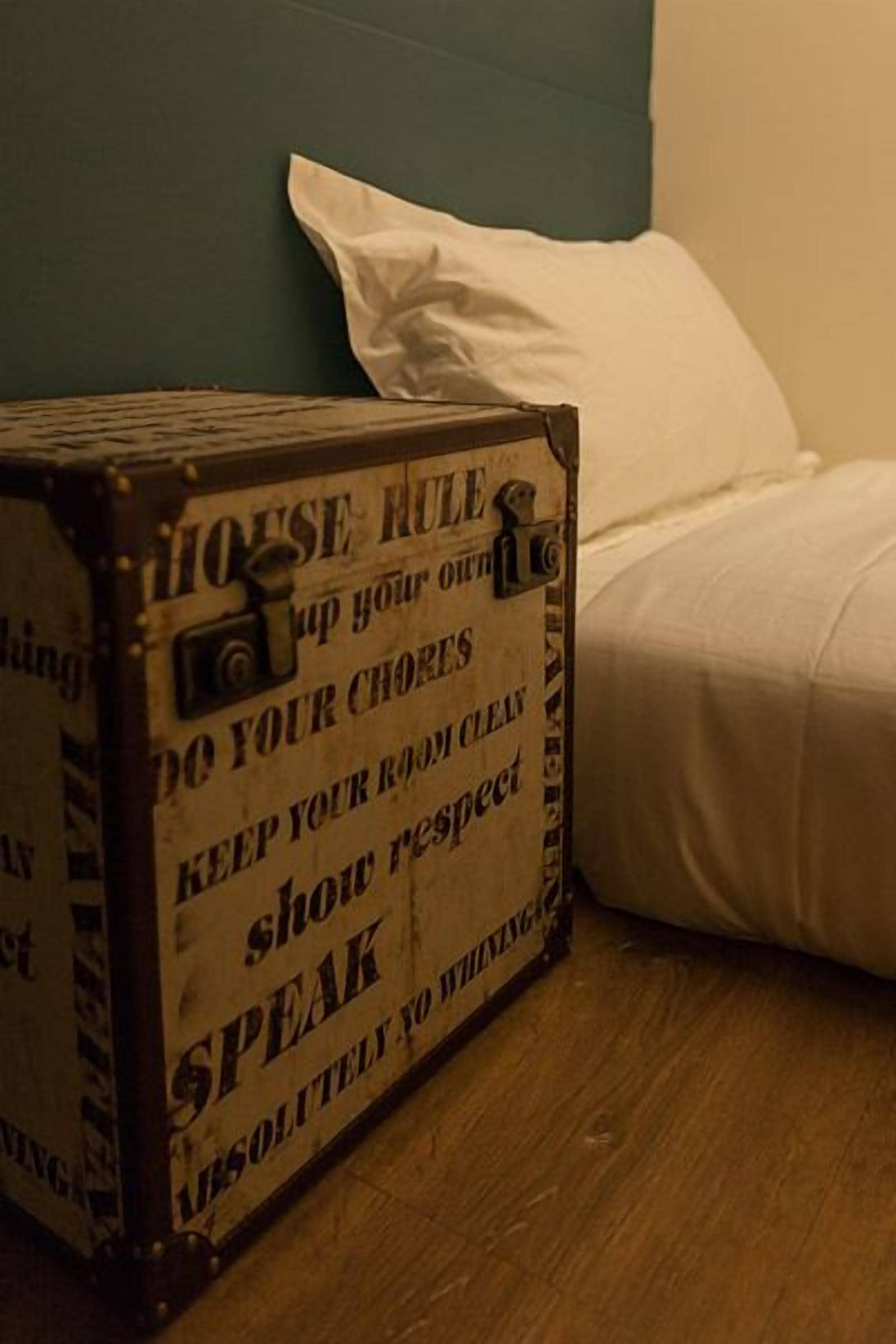 Une boîte en bois portant des inscriptions invitant les clients à garder leur chambre propre, à faire preuve de respect et à éviter toute conversation inutile ou déplacée.