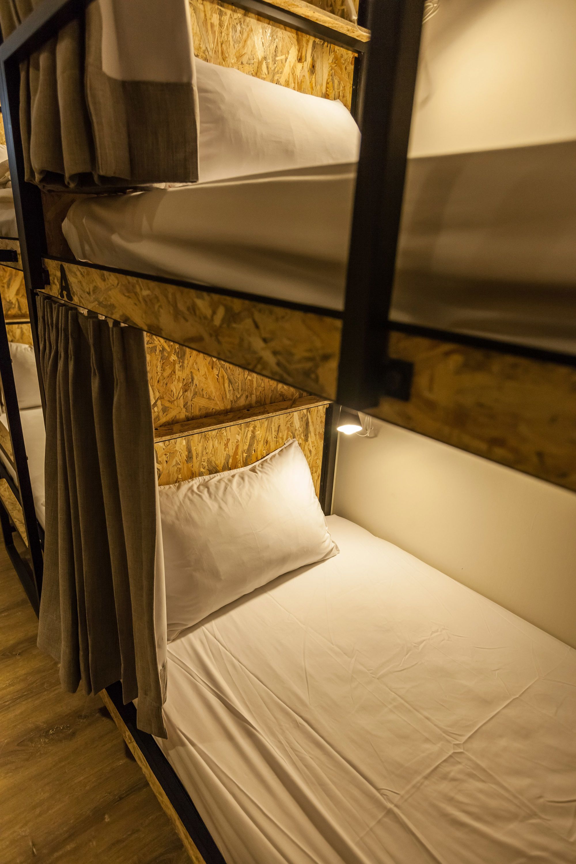 A bunk bed with multiple levels, each with a pillow and a blanket.