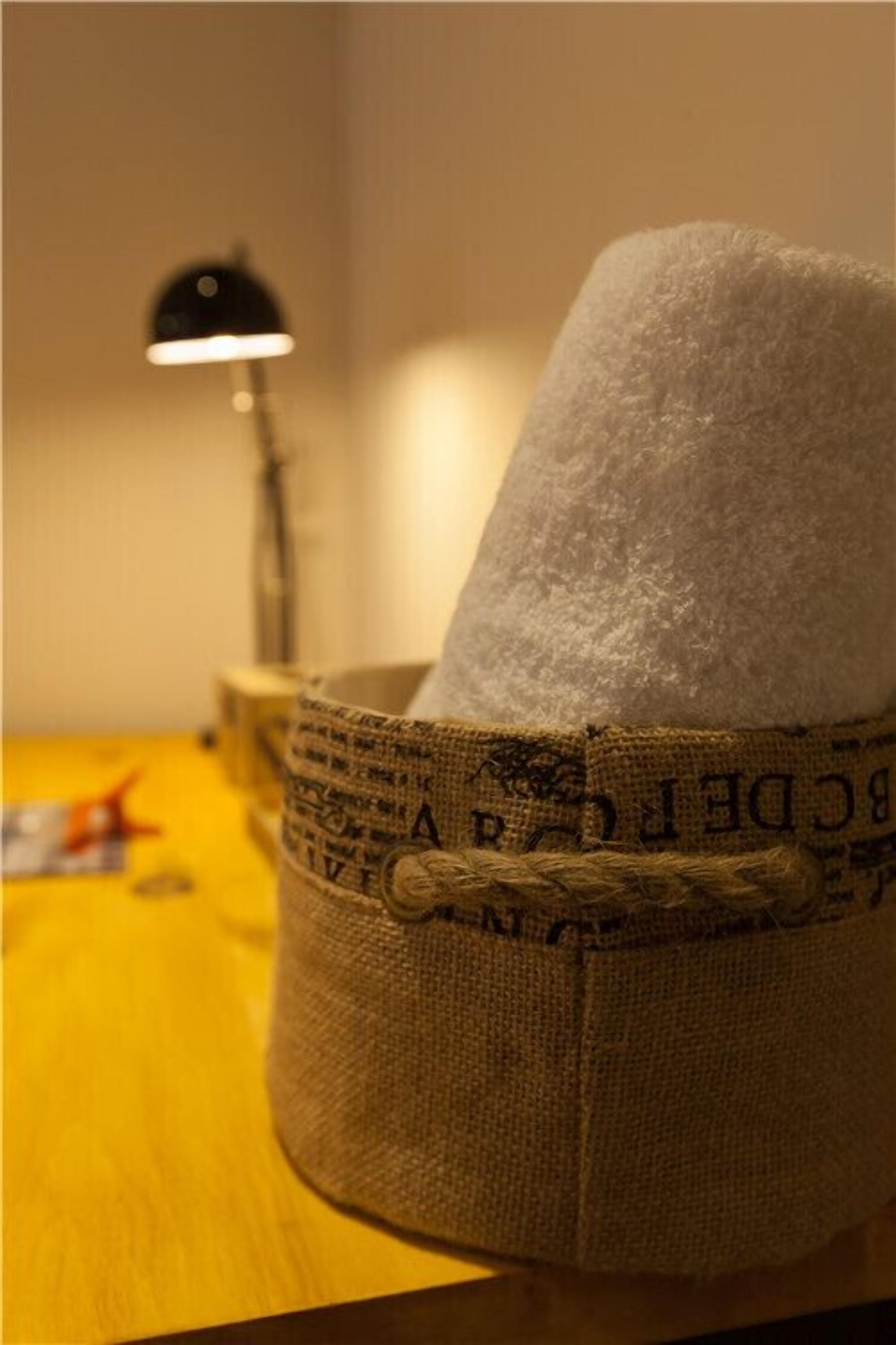 Un sac de jute amb un objecte blanc a dins, lligat per dalt, sobre una superfície de fusta.