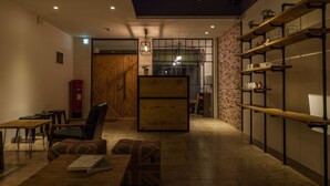 Un café acogedor con mobiliario de madera, una pared de ladrillo y estantes con objetos.
