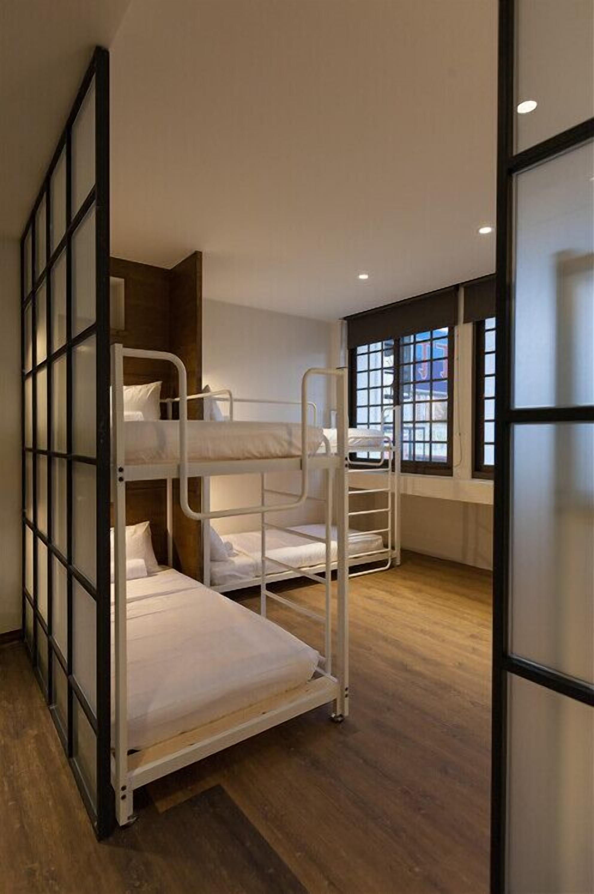 Ein Schlafzimmer mit Etagenbetten, einem Fenster und Blick auf Gebäude.