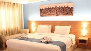 A hotel room with a large bed, two bedside tables, a chair, and a wall-mounted picture. - Sahid Mutiara Karawaci (Curug)