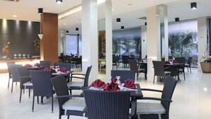 A modern restaurant with high ceilings, ample natural light, and a variety of seating options including tables and chairs. - Sahid Mutiara Karawaci (Curug)