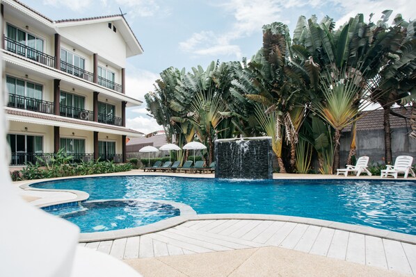 Alberca al aire libre, sombrillas en la alberca y camastros 