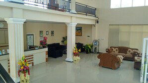 A spacious lobby with a reception desk, two sofas, a fan, and a staircase. - Amazing Beach Resort - Palu (Palu)