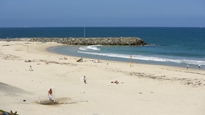 A beach with a rocky breakwater, sandy shore, and clear blue sky. - Club Wyndham Perth, Trademark Collection by Wyndham (West Perth)