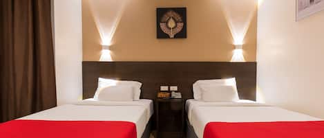 A hotel room with two beds, a nightstand, and a wall-mounted artwork.