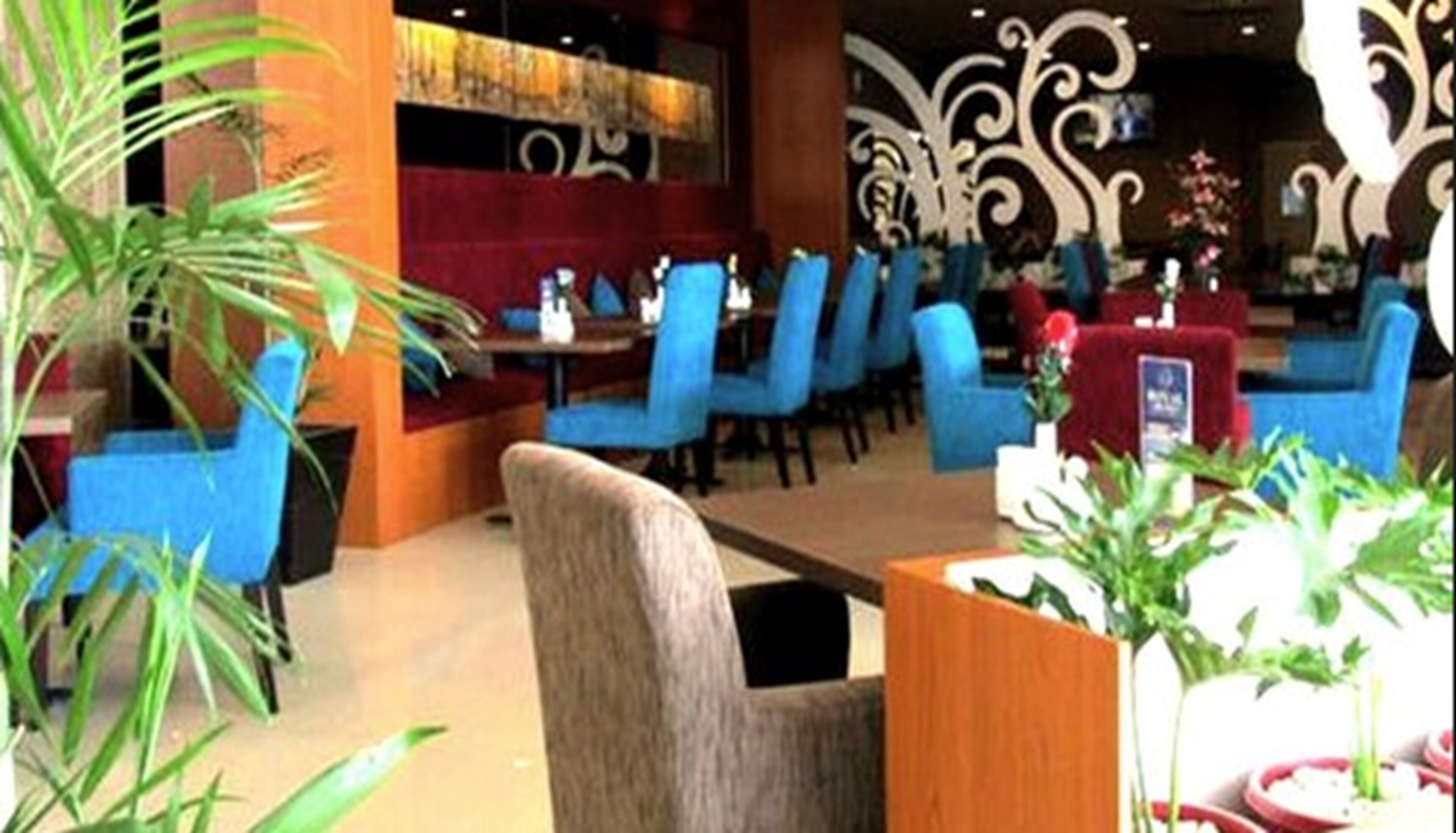 A restaurant with blue chairs, a wooden table, and decorative wall art.