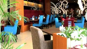 A restaurant with blue chairs, a wooden table, and decorative wall art.