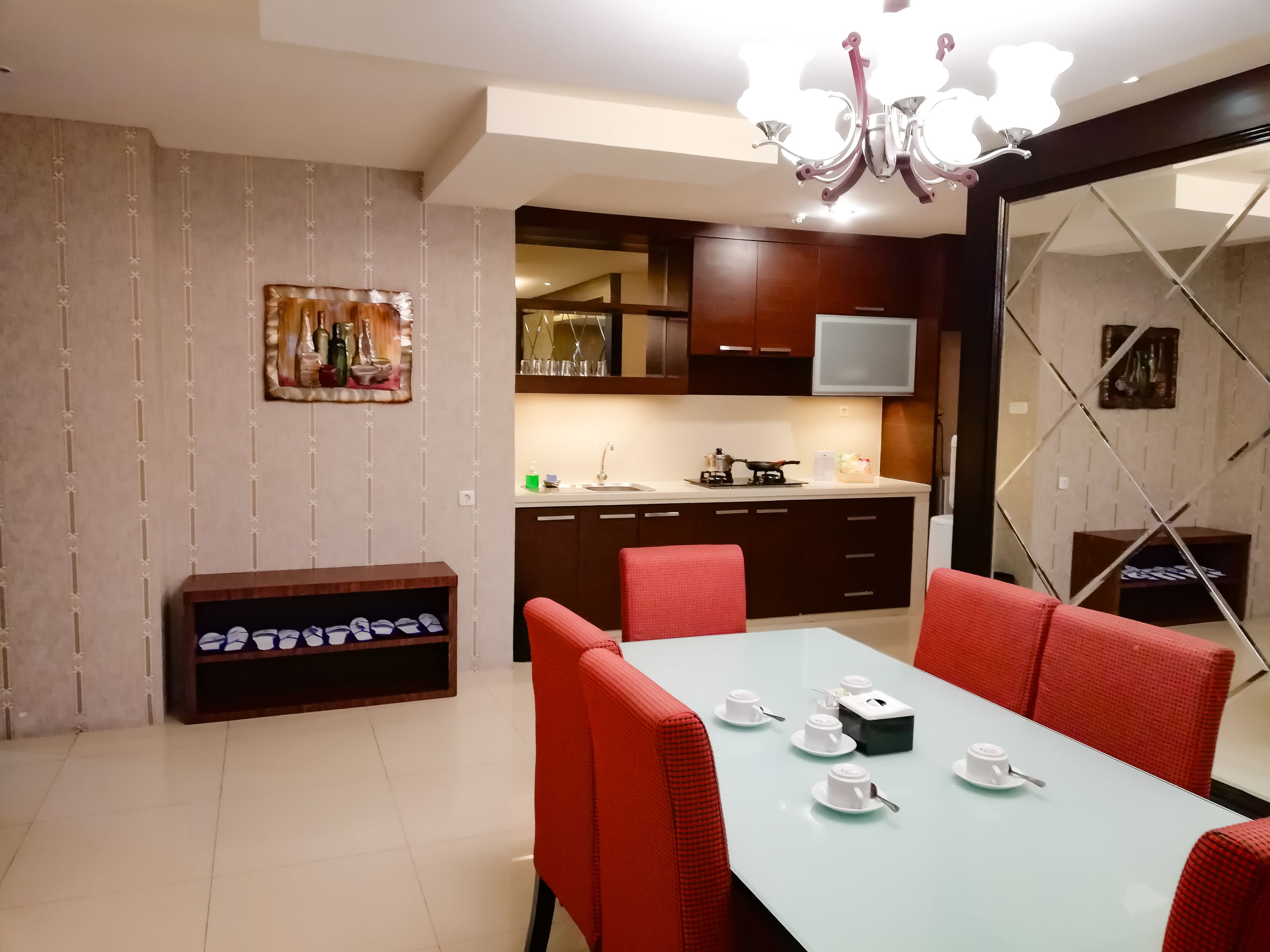 Una cucina moderna con mobili scuri, un piano di lavoro bianco e una TV integrata.