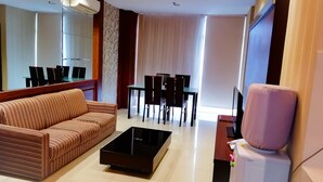 Un salon moderne comprenant un canapé, une table basse, une table à manger avec des chaises et un téléviseur.