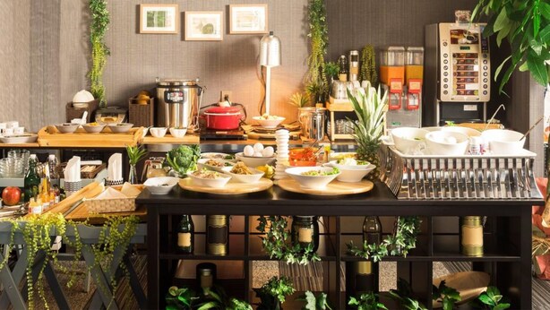 Ein Essbereich mit einem Buffet, einschließlich verschiedener Speisen und einer Kaffeemaschine.