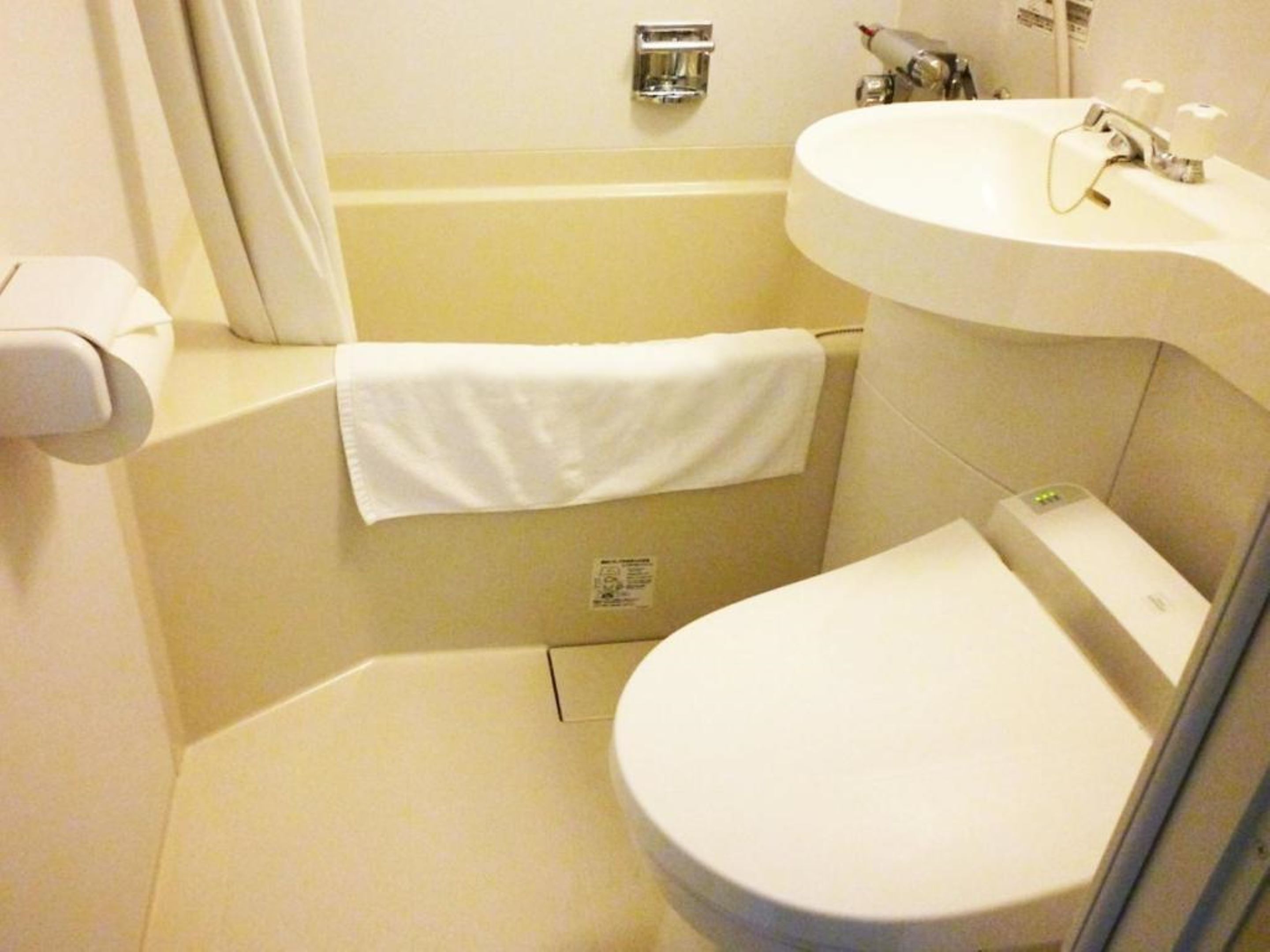 A bathroom with a toilet, sink, and shower.