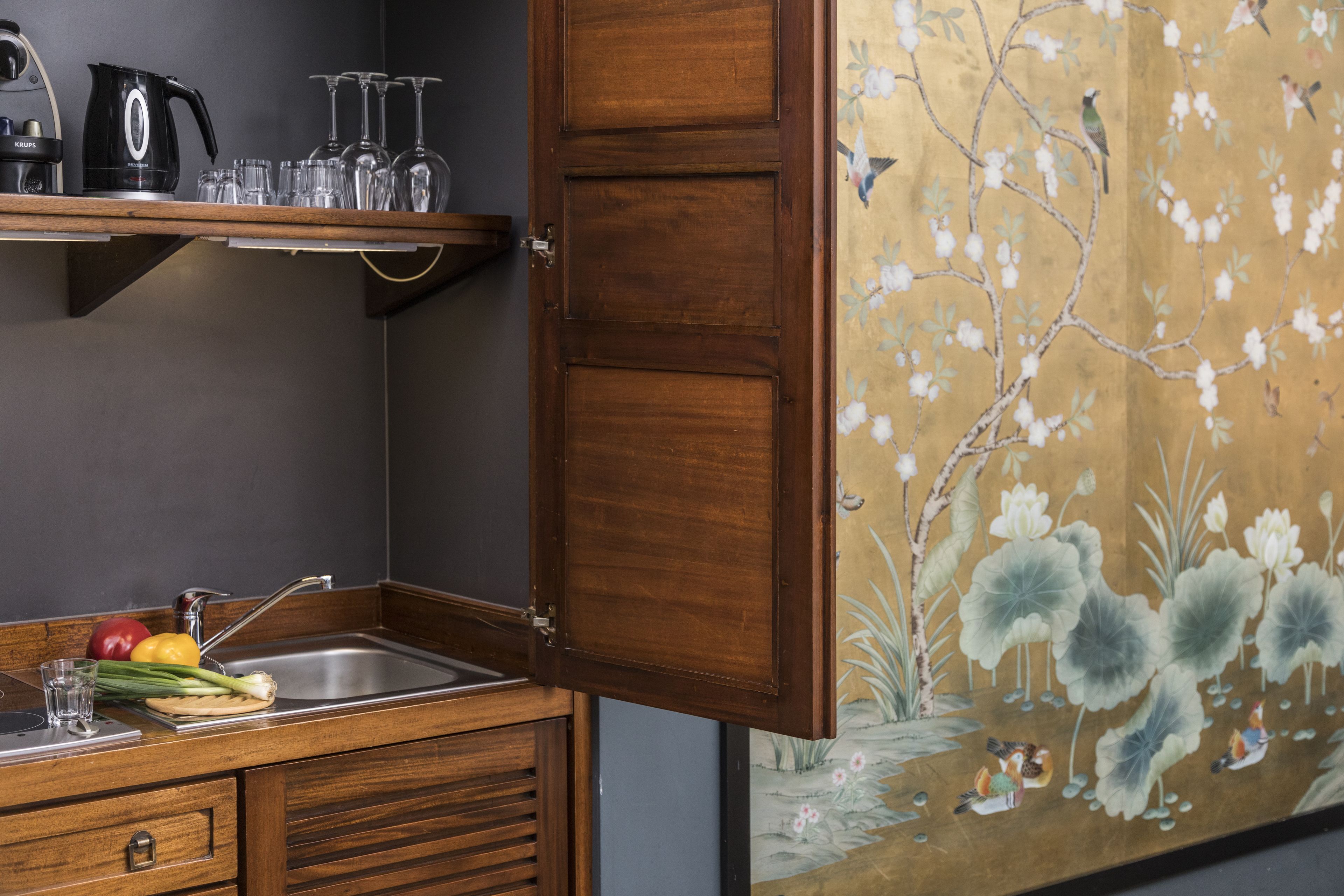 A kitchen with wooden cabinets, a stainless steel sink, and a coffee maker.