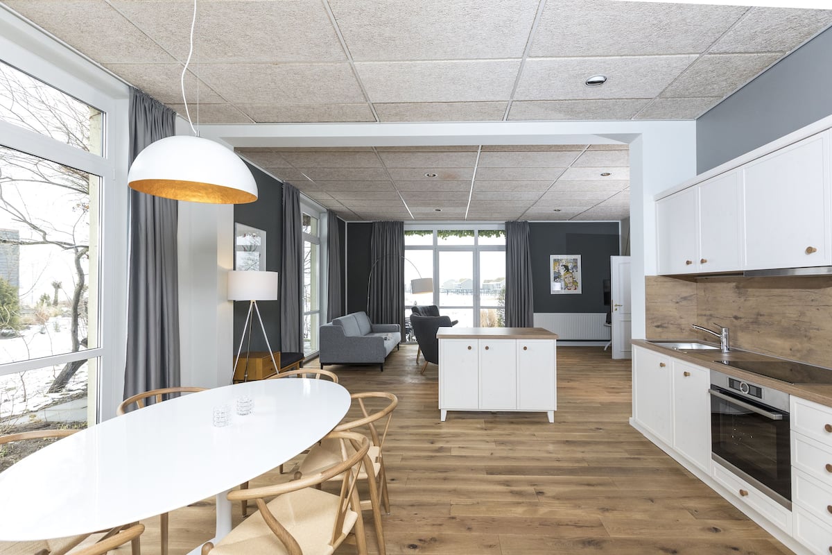 A modern kitchen with white cabinets, a wooden countertop, and a built-in oven.
