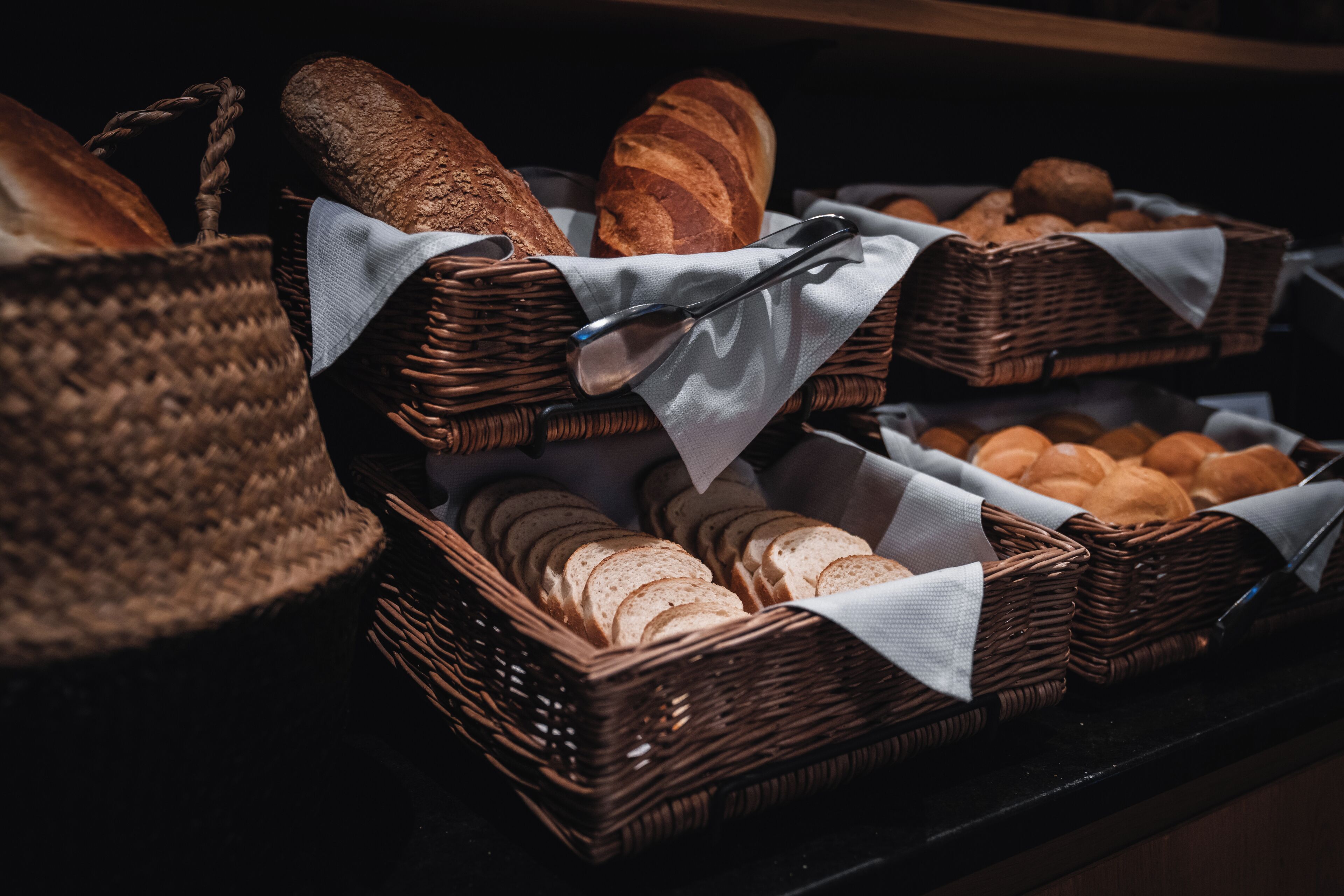Wicker baskets filled with bread and pastries, arranged on a counter.