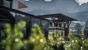 Un edificio moderno con amplios ventanales que dan a un paisaje montañoso.