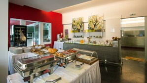 A buffet setup with various food items and a kitchen area in the background. - Nefeli Villas (Skiros)