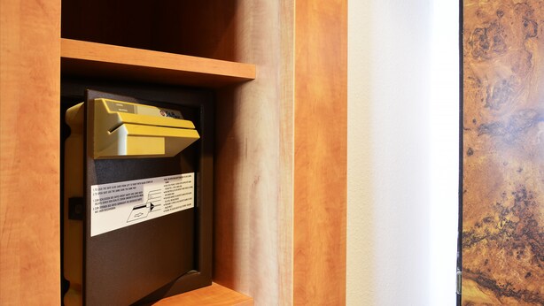 Un meuble en bois avec une étiquette et un objet jaune à l’intérieur.