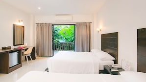 A hotel room with a bed, a desk, and a view of greenery outside. - Wilacha Chiang Rai (Chiang Rai)