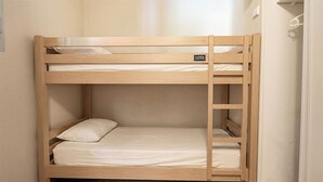 A bunk bed with a ladder, a pillow, and a sign on the headboard.