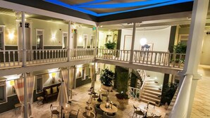 Un vestíbulo de hotel de varios niveles con balcones, zonas de estar y una fuente central.