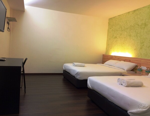 A hotel room with two beds, a desk, and a green textured wall. - Dream Garden Hotel (Klang)