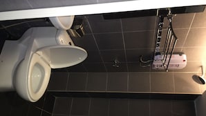 A bathroom with a toilet, a bidet, and a shower control panel. - Dream Garden Hotel (Klang)