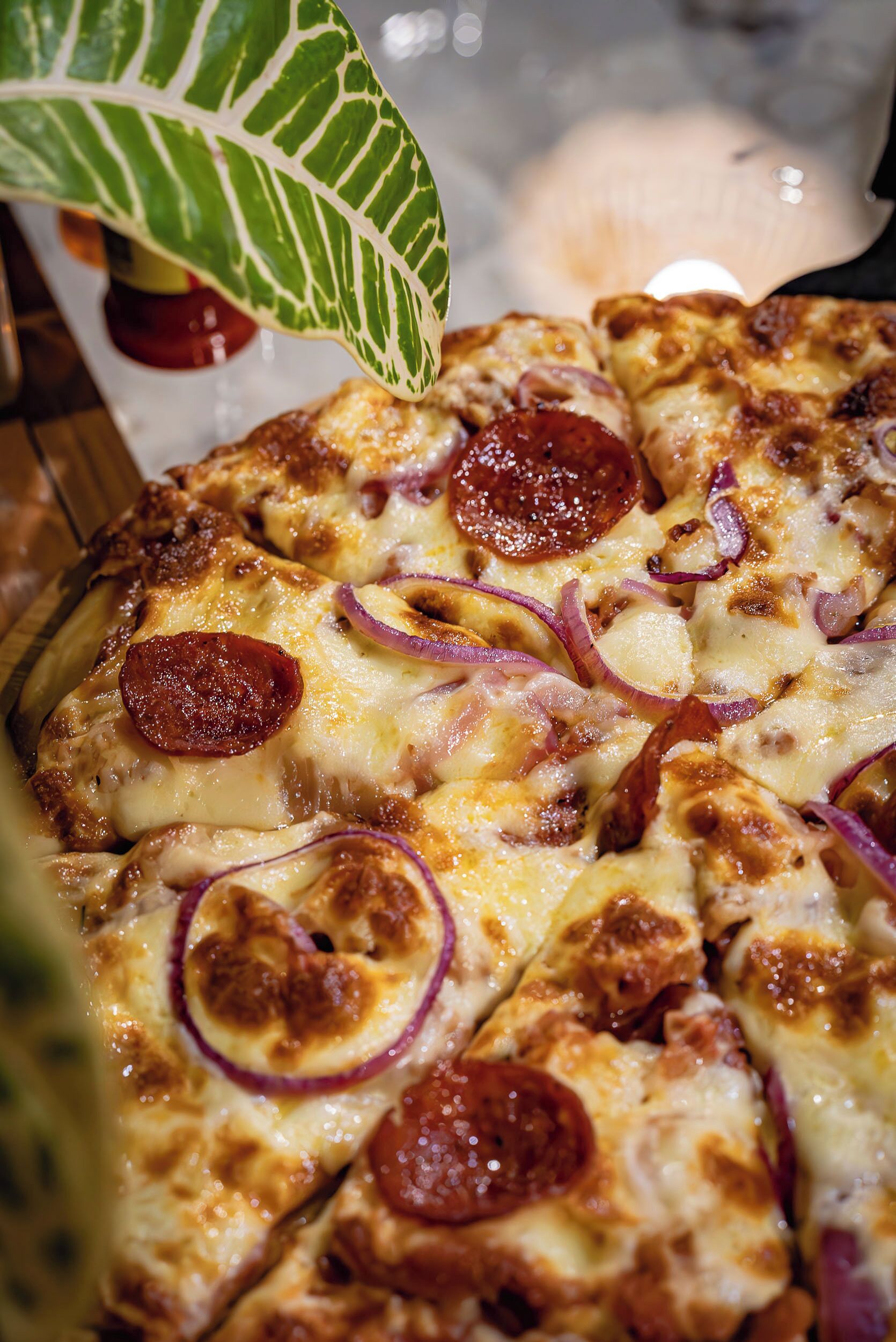 Une pizza à la saucisse piquante et aux oignons.