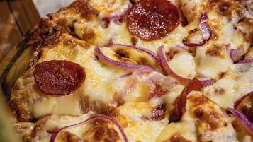 Une pizza à la saucisse piquante et aux oignons.