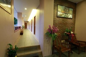 A hotel hallway with a staircase, a reception desk, and a painting on the wall. - Baanmalai Hotel Chiangrai (Chiang Rai)