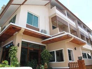 A multi-story residential building with balconies, large windows, and a garden area with a fountain. - Baanmalai Hotel Chiangrai (Chiang Rai)